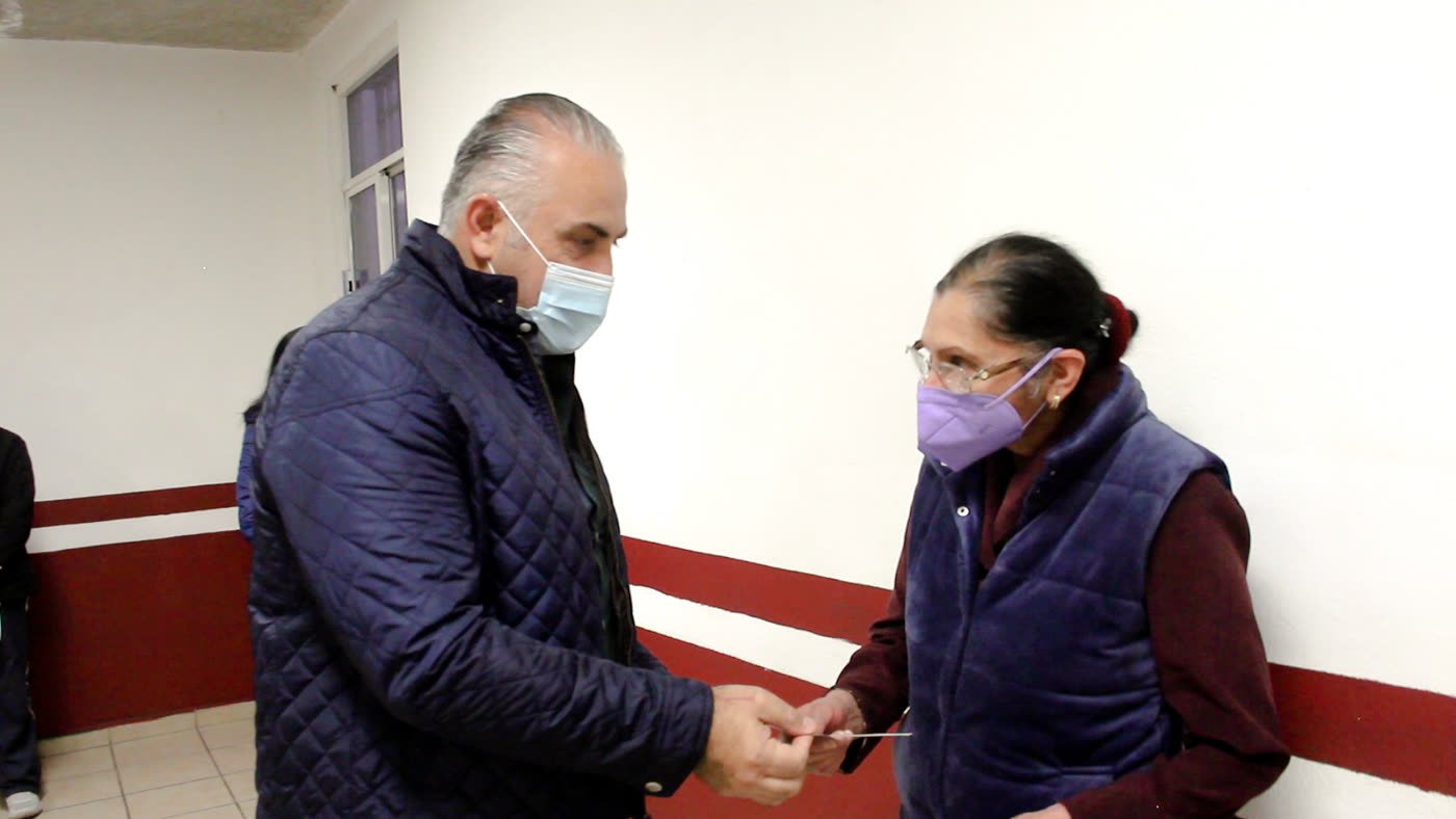 Entrega de vale de apoyo visual a una persona adulta mayor.